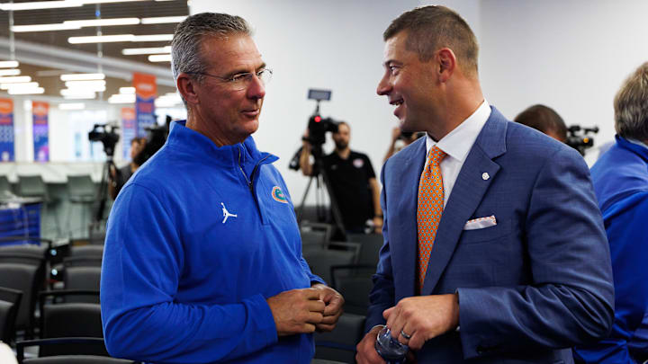 Dec 1, 2025; Gainesville, FL, USA; Florida Gators former head coach Urban Meyer and Florida Gators head coach Jon Sumrall talk after the press conference.