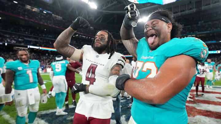 Washington Commanders linebacker Frankie Luvu (4) poses with Miami Dolphins guard Jonah Savaiinaea (72) after the 2025 NFL Madrid Game at Santiago Bernabeu Stadium. 
