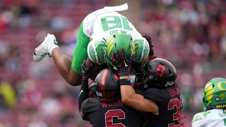 Sep 30, 2023; Stanford, California, USA; Oregon Ducks tight end Kenyon Sadiq (18) attempts to leap over Stanford Cardinal cornerback Collin Wright (6) and safety Mitch Leigber (32) during the second quarter at Stanford Stadium.