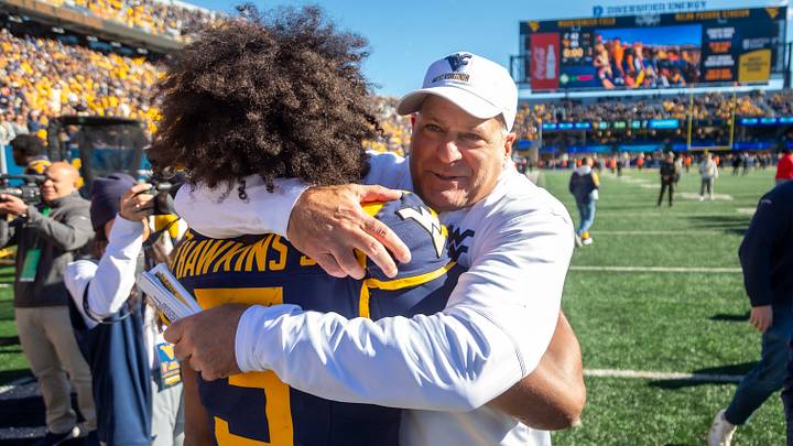 Oct 17, 2026; Morgantown, West Virginia, USA; West Virginia Mountaineers head coach Rich Rodriguez celebrates with quarterback Michael Hawkins Jr. (3) after defeating the Cincinnati Bearcats at Milan Puskar Stadium. Mandatory Credit: Ben Queen-Imagn Images Oct 17, 2026; Morgantown, West Virginia, USA; West Virginia Mountaineers head coach Rich Rodriguez celebrates with quarterback Michael Hawkins Jr. (3) after defeating the Cincinnati Bearcats at Milan Puskar Stadium. Mandatory Credit: Ben Queen-Imagn Images