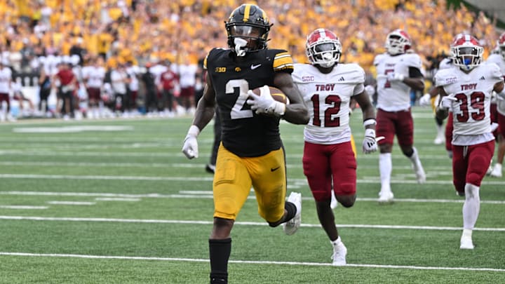 Sep 14, 2024; Iowa City, Iowa, USA; Iowa Hawkeyes running back Kaleb Johnson (2) scores on a 33 yard run as Troy Trojans cornerback Trent Henry (12) and safety Ian Conerly-Goodly (39) pursue during the fourth quarter at Kinnick Stadium. Mandatory Credit: Jeffrey Becker-Imagn Images