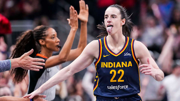 Indiana Fever guard Caitlin Clark (22) high-fives fans after scoring a 3-pointer Saturday, June 14, 2025, during a game between the Indiana Fever and the New York Liberty at Gainbridge Fieldhouse in Indianapolis.