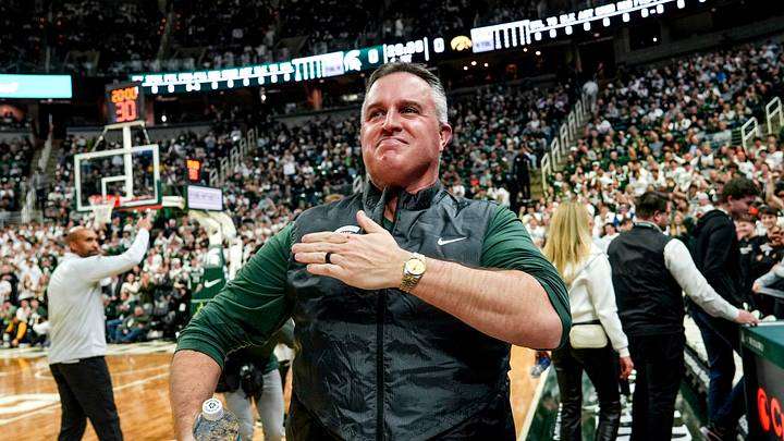 Michigan State's new football coach Pat Fitzgerald pats his heart at the crowd in attendance for the Spartans basketball game against Iowa on Tuesday, Dec. 2, 2025, at the Breslin Center in East Lansing. Michigan State's new football coach Pat Fitzgerald pats his heart at the crowd in attendance for the Spartans basketball game against Iowa on Tuesday, Dec. 2, 2025, at the Breslin Center in East Lansing.