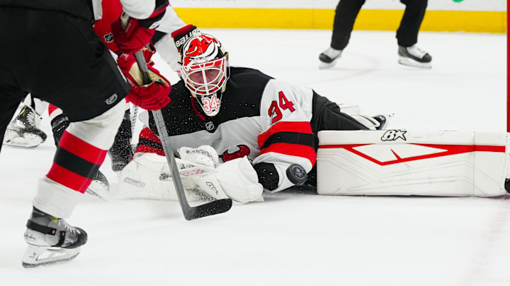 Dec 28, 2024; Raleigh, North Carolina, USA;  New Jersey Devils goaltender Jake Allen (34) stops the shot against the Carolina Hurricanes during the first period at Lenovo Center. Mandatory Credit: James Guillory-Imagn Images