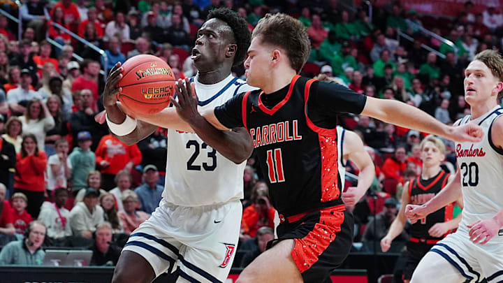 Ballard Jude Gibson (23) drives to the basket as Carroll guard Landon Petersen (11) defends during the first quarter in the 3A IIHSAA boys basketball semifinal. on March 11, 2026, at Casey’s Center in Des Moines, Iowa.