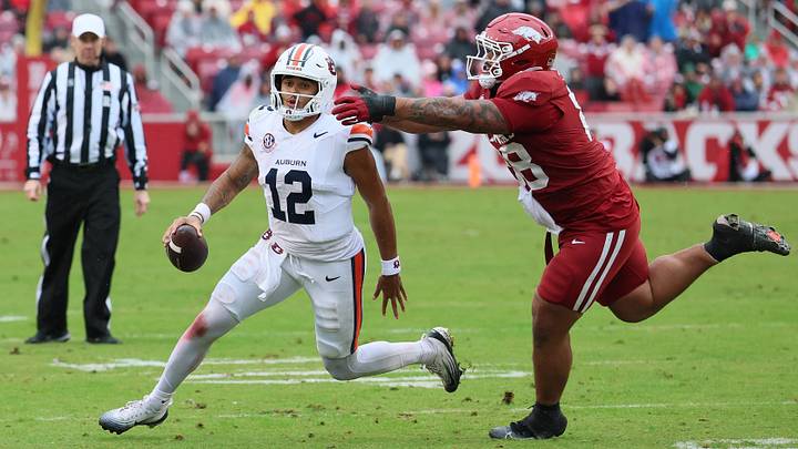 Auburn Tigers quarterback Ashton Daniels (12) rushes during the third quarter as Arkansas Razorbacks defensive tackle Danny Saili (88) defends at Donald W. Reynolds Razorback Stadium. Auburn Tigers quarterback Ashton Daniels (12) rushes during the third quarter as Arkansas Razorbacks defensive tackle Danny Saili (88) defends at Donald W. Reynolds Razorback Stadium.