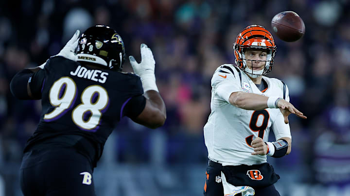 Cincinnati Bengals quarterback Joe Burrow (9) and Baltimore Ravens defensive tackle Travis Jones (98)