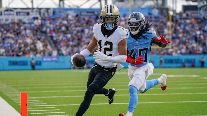 Dec 28, 2025; Nashville, Tennessee, USA; New Orleans Saints wide receiver Chris Olave (12) runs in a touchdown in front of Tennessee Titans cornerback Kemon Hall (40) during the third quarter  at Nissan Stadium. Mandatory Credit: Andrew Nelles-USA TODAY Network via Imagn Images
