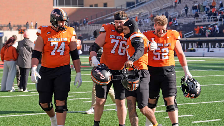 Oklahoma State's Grant Seagren (74), Bob Schick (76), Oklahoma State's Landyn Cleveland (14), and Kasen Carpenter (52) walk of the field following the college football game between the Oklahoma State Cowboys and the Iowa State Cyclones at Boone Pickens Stadium in Stillwater, Okla., Saturday Nov. 29, 2025.
