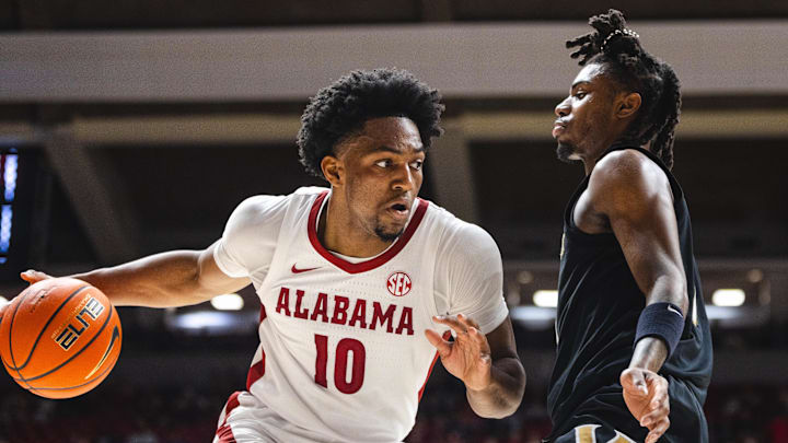 Jan 21, 2025; Tuscaloosa, Alabama, USA; Alabama Crimson Tide forward Mouhamed Dioubate (10) drives the ball against Vanderbilt Commodores guard Jason Edwards (1) during the first half at Coleman Coliseum. Mandatory Credit: Will McLelland-Imagn Images