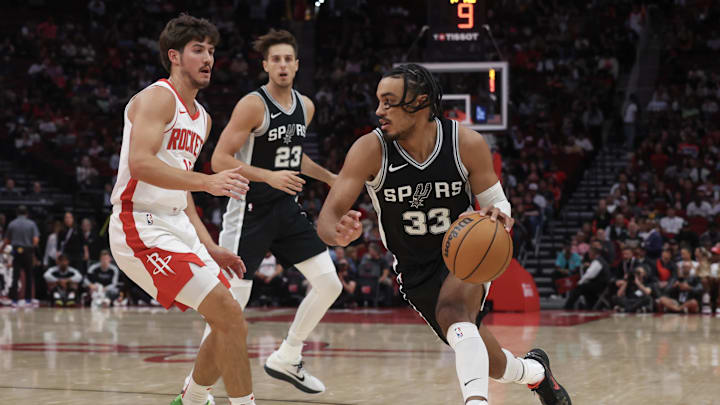 Oct 17, 2024; Houston, Texas, USA; San Antonio Spurs guard Tre Jones (33) dribbles against Houston Rockets guard Reed Sheppard (15) in the second quarter at Toyota Center.