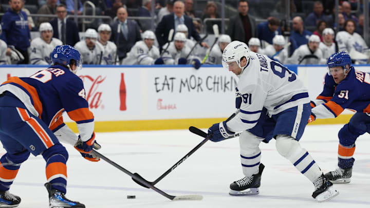 Jan 3, 2026; Elmont, New York, USA; Toronto Maple Leafs center John Tavares (91) skates with the puck defended by New York Islanders defenseman Matthew Schaefer (48) during the third period at UBS Arena. Mandatory Credit: Thomas Salus-Imagn Images