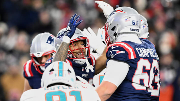 Jan 4, 2026; Foxborough, Massachusetts, USA; New England Patriots running back TreVeyon Henderson (32) celebrates with teammates after scoring a touchdown against the Miami Dolphins during the third quarter at Gillette Stadium.