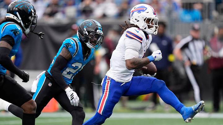 Oct 26, 2025; Charlotte, North Carolina, USA; Buffalo Bills running back James Cook III (4) scores a touchdown against Carolina Panthers safety Nick Scott (21) during the second half at Bank of America Stadium. Mandatory Credit: Jim Dedmon-Imagn Images