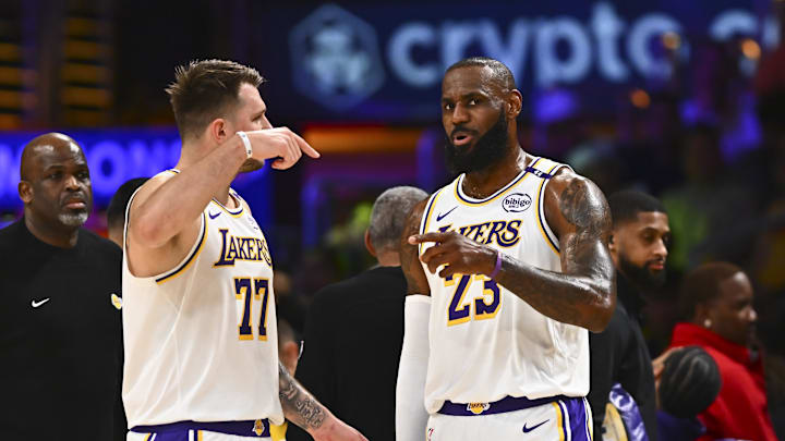 Mar 22, 2025; Los Angeles, California, USA: Los Angeles Lakers guard Luka Doncic (77) and Los Angeles Lakers forward LeBron James (23) on the sidelines against the Chicago Bulls during the first half at Crypto.com Arena. Mandatory Credit: Jonathan Hui-Imagn Images