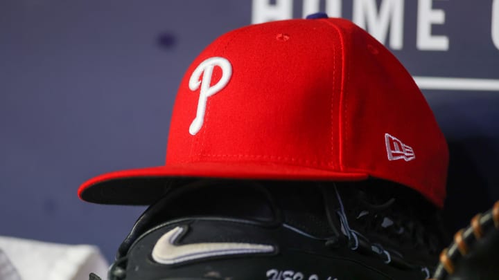 May 26, 2023; Atlanta, Georgia, USA; A detailed view of a Philadelphia Phillies hat and glove on the bench against the Atlanta Braves in the seventh inning at Truist Park. 