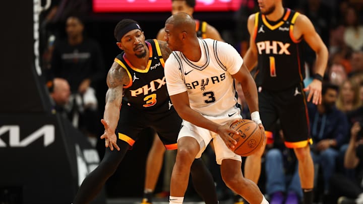 Dec 3, 2024; Phoenix, Arizona, USA; San Antonio Spurs guard Chris Paul (right) controls the ball against Phoenix Suns guard Bradley Beal in the second half of an NBA Cup game at Footprint Center. Mandatory Credit: Mark J. Rebilas-Imagn Images