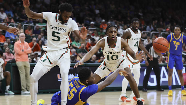 Jan 27, 2024; Coral Gables, Florida, USA; Pittsburgh Panthers forward Zack Austin (55) passes the basketball as he is defended by Miami Hurricanes guard Wooga Poplar (5) and guard Paul Djobet (10) during the first half at Watsco Center. Mandatory Credit: Sam Navarro-Imagn Images Jan 27, 2024; Coral Gables, Florida, USA; Pittsburgh Panthers forward Zack Austin (55) passes the basketball as he is defended by Miami Hurricanes guard Wooga Poplar (5) and guard Paul Djobet (10) during the first half at Watsco Center. Mandatory Credit: Sam Navarro-Imagn Images