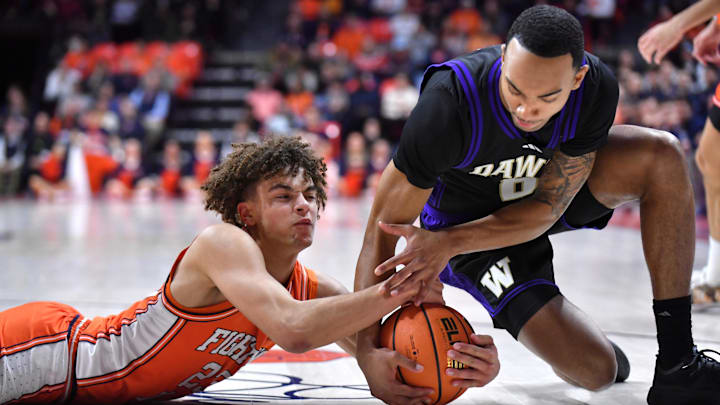 Illinois guard Keaton Wagler (23) and Huskies forward Bryson Tucker (8) wrestle for a loose ball. 
