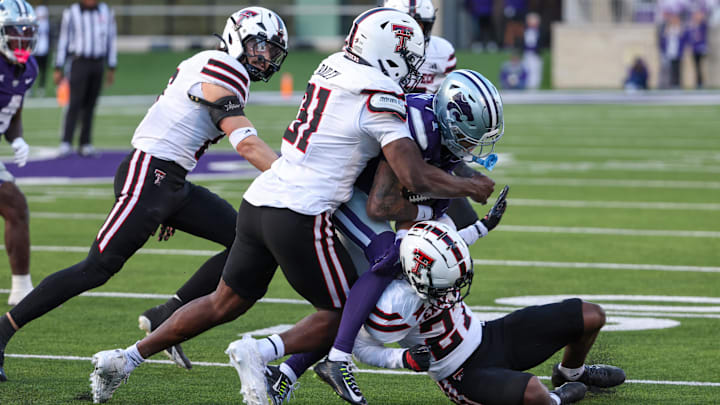 Nov 1, 2025; Manhattan, Kansas, USA; Kansas State Wildcats wide receiver Jayce Brown (1) is tackled by Texas Tech Red Raiders defensive back Amier Boyd (27) and linebacker David Bailey (31) during the third quarter at Bill Snyder Family Football Stadium. Mandatory Credit: Scott Sewell-Imagn Images
