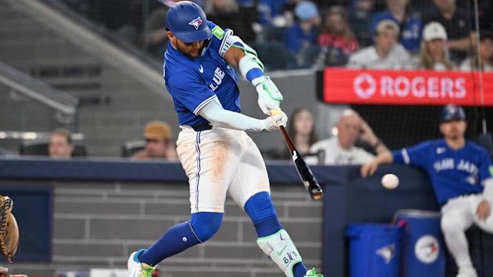 Mar 29, 2025; Toronto, Ontario, CAN;  Toronto Blue Jays shortstop Bo Bichette (11) hits a single against the Baltimore Orioles in the seventh inning at Rogers Centre.