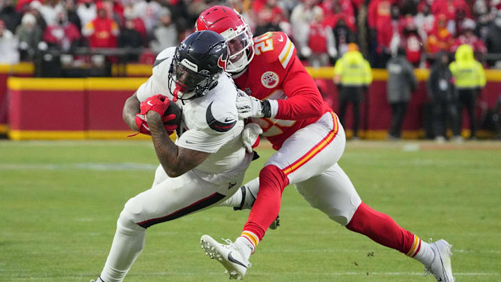 Jan 18, 2025; Kansas City, Missouri, USA; Houston Texans running back Dare Ogunbowale (33) runs the ball as Kansas City Chiefs safety Justin Reid (20) makes the tackle during the second half of a 2025 AFC divisional round game at GEHA Field at Arrowhead Stadium. Mandatory Credit: Denny Medley-Imagn Images