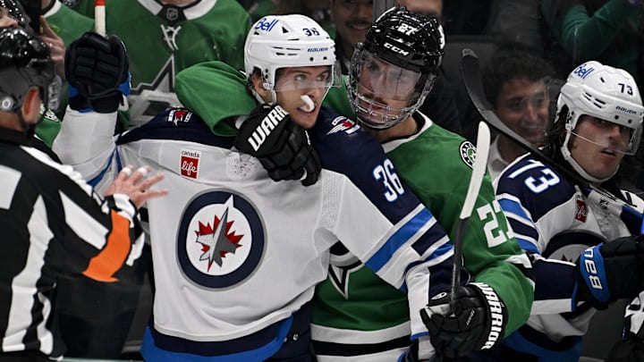 Apr 10, 2025; Dallas, Texas, USA; Dallas Stars left wing Mason Marchment (27) holds back Winnipeg Jets center Morgan Barron (36) during the first period at the American Airlines Center. Mandatory Credit: Jerome Miron-Imagn Images