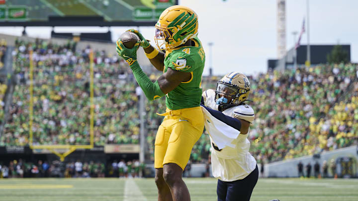 Aug 30, 2025; Eugene, Oregon, USA; Oregon Ducks wide receiver Malik Benson (4) catches a touchdown pass during the first half against Montana State Bobcats defensive back Seth Johnson (9) at Autzen Stadium. Mandatory Credit: Troy Wayrynen-Imagn Images
