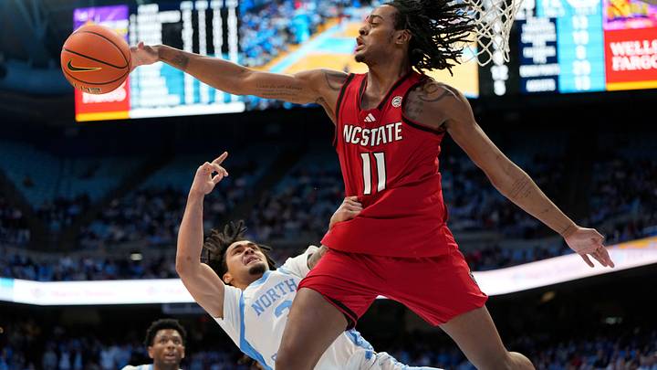 Feb 19, 2025; Chapel Hill, North Carolina, USA; North Carolina Tar Heels guard Elliot Cadeau (3) shoots as North Carolina State Wolfpack guard Dennis Parker Jr. (11) defends in the second half at Dean E. Smith Center. Mandatory Credit: Bob Donnan-Imagn Images