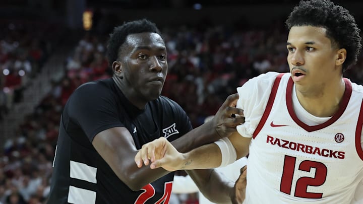 Oct 24, 2025; Fayetteville, AR, USA; Arkansas Razorbacks forward Malique Twin (12) drives against Cincinnati Bearcats forward Tyler McKinley (24) during the second half at Bud Walton Arena. Arkansas won 89-61. Mandatory Credit: Nelson Chenault-Imagn Images