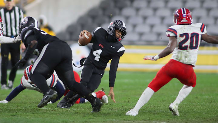 Aliquippa's Quentin Goode (4) attempts to juke McKeesport's Kemon Spell (20) during the first half of the WPIAL 4A Championship game Friday evening at Acrisure Stadium in Pittsburgh, PA.