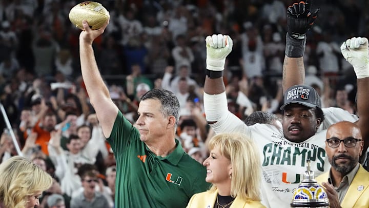 Miami Hurricanes head coach Mario Cristobal lifts the trophy after defeating Ole Miss 31-27 in the Vrbo Fiesta Bowl and CFP semifinal game at State Farm Stadium on Jan. 8, 2026, in Glendale.
