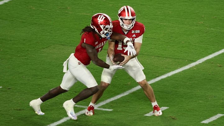 Jan 19, 2026; Miami Gardens, FL, USA; Indiana Hoosiers quarterback Fernando Mendoza (15) hands the ball to running back Roman Hemby (1) against the Miami Hurricanes in the first quarter during the College Football Playoff National Championship game at Hard Rock Stadium. Mandatory Credit: Kim Klement Neitzel-Imagn Images