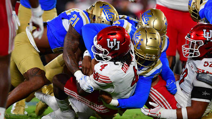 Aug 30, 2025; Pasadena, California, USA;  Utah Utes quarterback Devon Dampier (4) is brought down by the against the UCLA Bruins defense during the first half at the Rose Bowl. Mandatory Credit: Gary A. Vasquez-Imagn Images