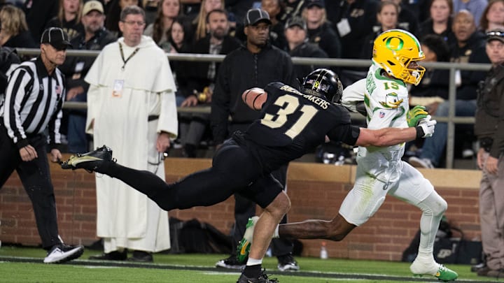 Oct 18, 2024; West Lafayette, Indiana, USA; Oregon Ducks wide receiver Tez Johnson (15) runs the ball toward the end zone past Purdue Boilermakers defensive back Dillon Thieneman (31) during the game at Ross-Ade Stadium. Mandatory Credit: Marc Lebryk-Imagn Images