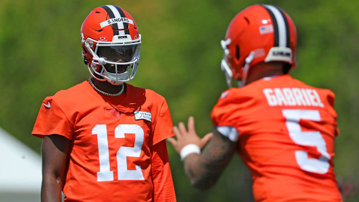 Cleveland Browns quarterback Shedeur Sanders (12) watches quarterback Dillon Gabriel (5) during day two of rookie minicamp May 10, 2025, in Berea, Ohio. Cleveland Browns quarterback Shedeur Sanders (12) watches quarterback Dillon Gabriel (5) during day two of rookie minicamp May 10, 2025, in Berea, Ohio.