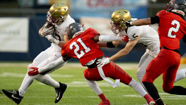 Dec 1, 2023; Canton, Ohio, USA;
Bishop Watterson's Ben Uhlenhake (42) attempts to make it past Toledo Central Catholic's Victor Singleton Jr. (21) as Christopher Bair (5) attempts to hold him back during their game on Friday, Dec. 1, 2023 at Tom Benson Hall of Fame Stadium for the Division III state finals.