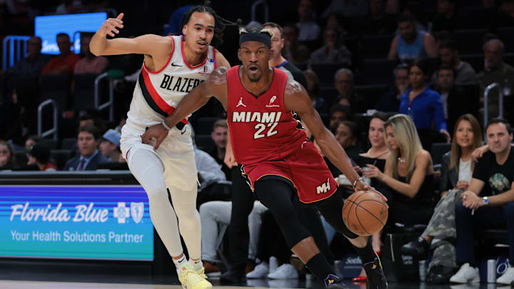 Jan 21, 2025; Miami, Florida, USA; Miami Heat forward Jimmy Butler (22) drives to the basket past Portland Trail Blazers guard Dalano Banton (5) during the first quarter at Kaseya Center. Mandatory Credit: Sam Navarro-Imagn Images