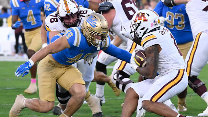 Oct 12, 2024; Pasadena, California, USA; UCLA Bruins linebacker Carson Schwesinger (49) moves to tackle Minnesota Golden Gophers running back Darius Taylor (1) during the first half at Rose Bowl. Mandatory Credit: Robert Hanashiro-Imagn Images