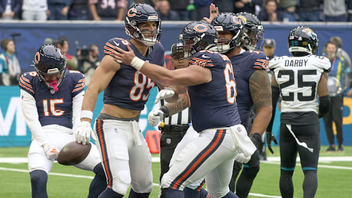 Cole Kmet celebrates with teammates in the end zone after one of his two TD catches, then he has to snap the ball on a PAT.