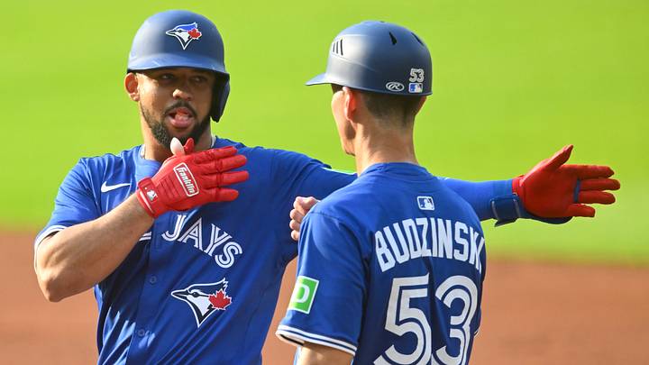Blue Jays right fielder Jonatan Clase (8) celebrates his single beside first base coach Mark Budzinski (53) in the second inning against the Cleveland Guardians