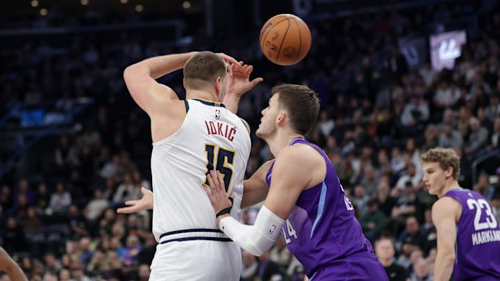 Denver Nuggets center Nikola Jokic (15) passes the ball over his back and past Utah Jazz center Walker Kessler (24) during the first quarter at Delta Center. Mandatory Credit: Chris Nicoll-Imagn Images