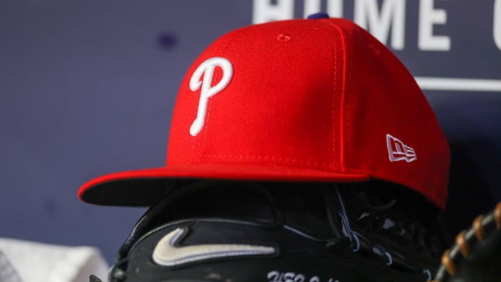 May 26, 2023; Atlanta, Georgia, USA; A detailed view of a Philadelphia Phillies hat and glove on the bench against the Atlanta Braves in the seventh inning at Truist Park. Mandatory Credit: Brett Davis-Imagn Images