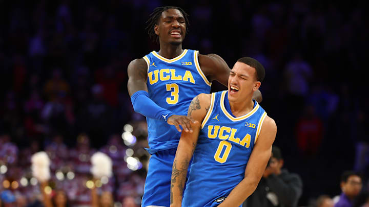 Dec 14, 2024; Phoenix, Arizona, USA; UCLA Bruins guard Kobe Johnson (0) celebrates with Eric Dailey Jr. (3) after defeating the Arizona Wildcats at Footprint Center. Mandatory Credit: Mark J. Rebilas-Imagn Images