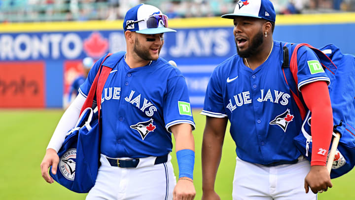 Feb 25, 2025:  Toronto Blue Jays shortstop Bo Bichette (11)  and designated hitter Vladimir Guerrero Jr. (27) walk towards the dugout before a spring training game against the St. Louis Cardinals  at TD Ballpark.