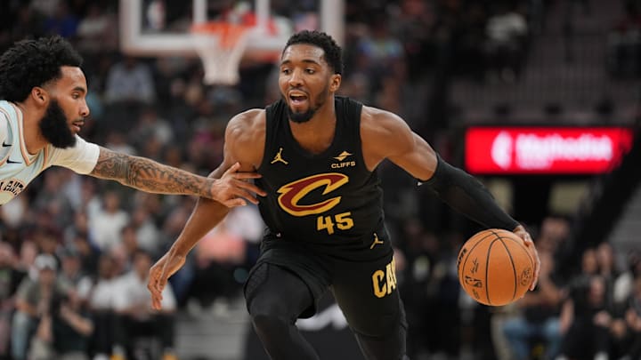Apr 4, 2025; San Antonio, Texas, USA;  Cleveland Cavaliers guard Donovan Mitchell (45) dribbles against San Antonio Spurs forward Julian Champagnie (30) in the first half at Frost Bank Center. Mandatory Credit: Daniel Dunn-Imagn Images