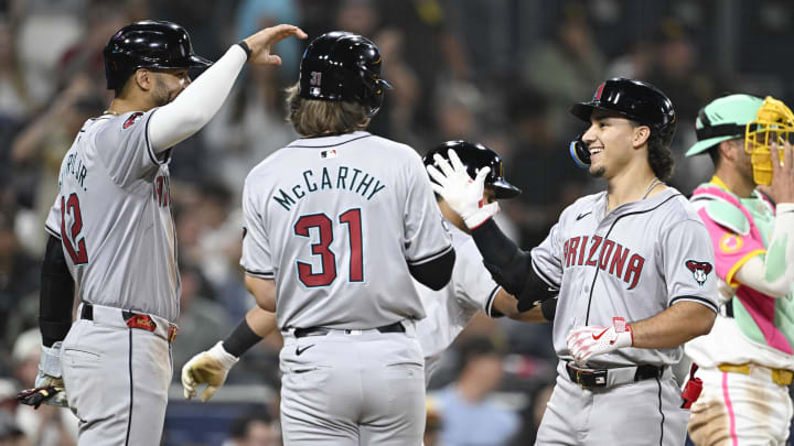 July 5, 2024; San Diego, California, USA; Arizona Diamondbacks center fielder Alek Thomas (5), right, is congratulated by Lourdes Gurriel Jr. (12) and Jake McCarthy (31) after hitting a grand slam during the ninth inning against the San Diego Padres at Petco Park. Mandatory Credit: Denis Poroy-USA TODAY Sports