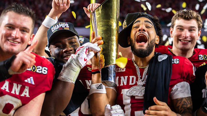 Indiana's Pat Coogan (78), Tyrique Tucker (95), Elijah Sarratt (13) and Fernando Mendoza (15) celebrate with the trophy after the College Football Playoff National Championship college football game at Hard Rock Stadium in Miami Gardens on Monday, Jan. 19, 2026.