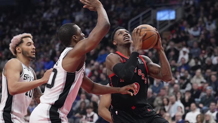 Mar 23, 2025; Toronto, Ontario, CAN; Toronto Raptors forward RJ Barrett (9) goes up to make a basket against San Antonio Spurs forward Keldon Johnson (0) during the first half at Scotiabank Arena. Mandatory Credit: John E. Sokolowski-Imagn Images