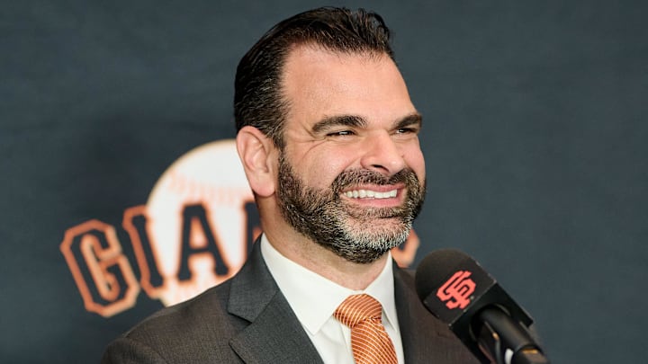 San Francisco Giants general manager Zack Minasian speaks to media behind a microphone.